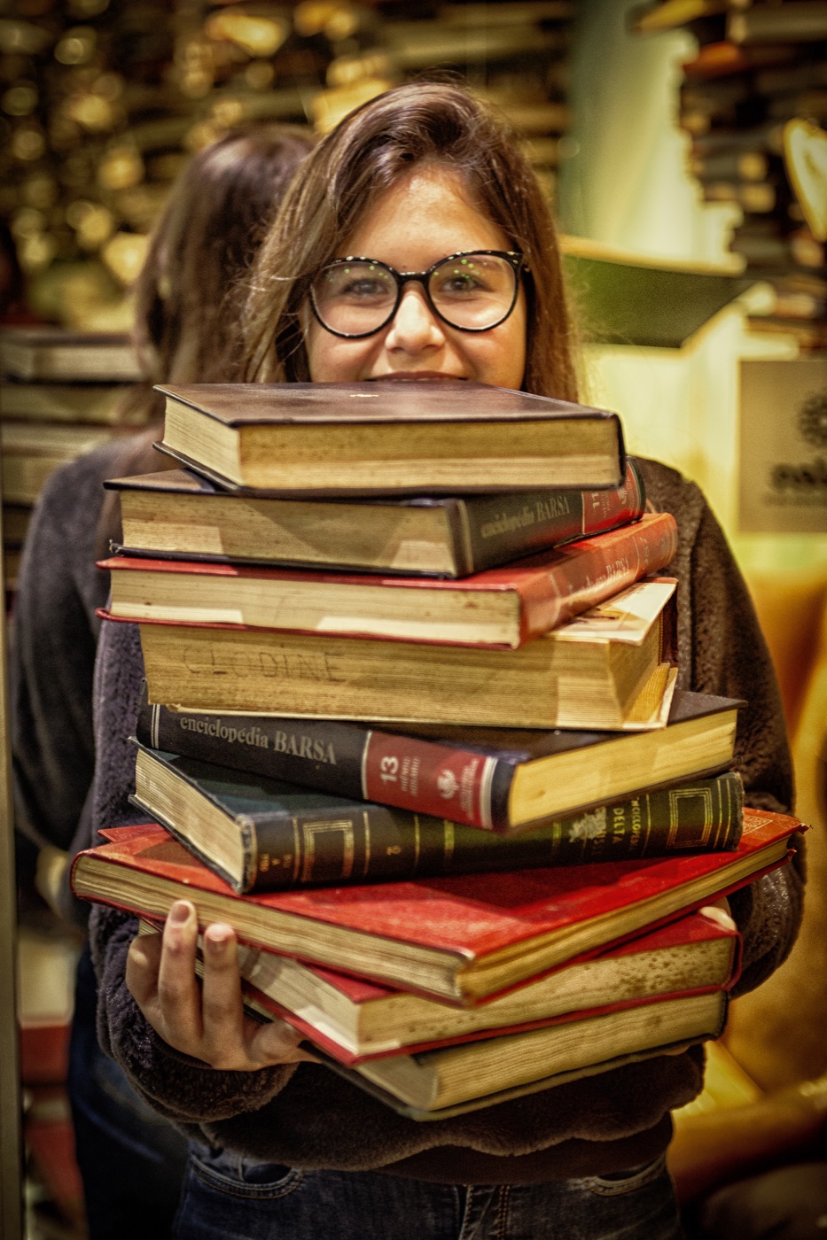 Visitante segurando uma pilha de livros na Bienal do Livro de Sao Paulo