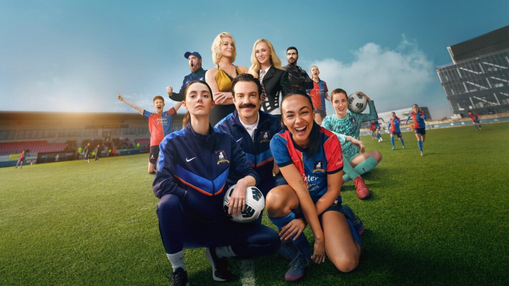 Elenco da 4ª temporada de Ted Lasso no gramado com o time feminino do AFC Richmond