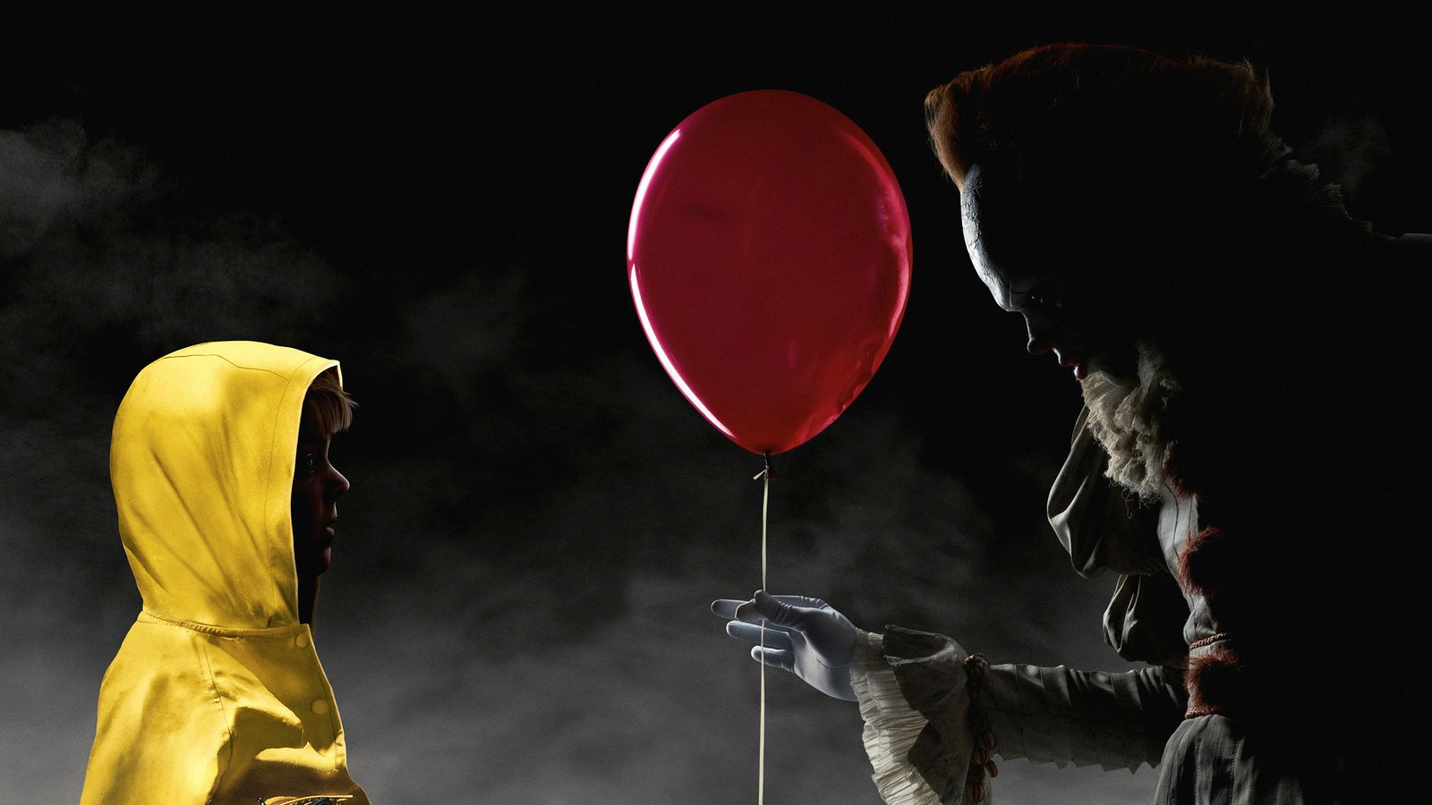 Georgie, de capa de chuva amarela, diante de Pennywise e do balão vermelho em It: A Coisa (2017)